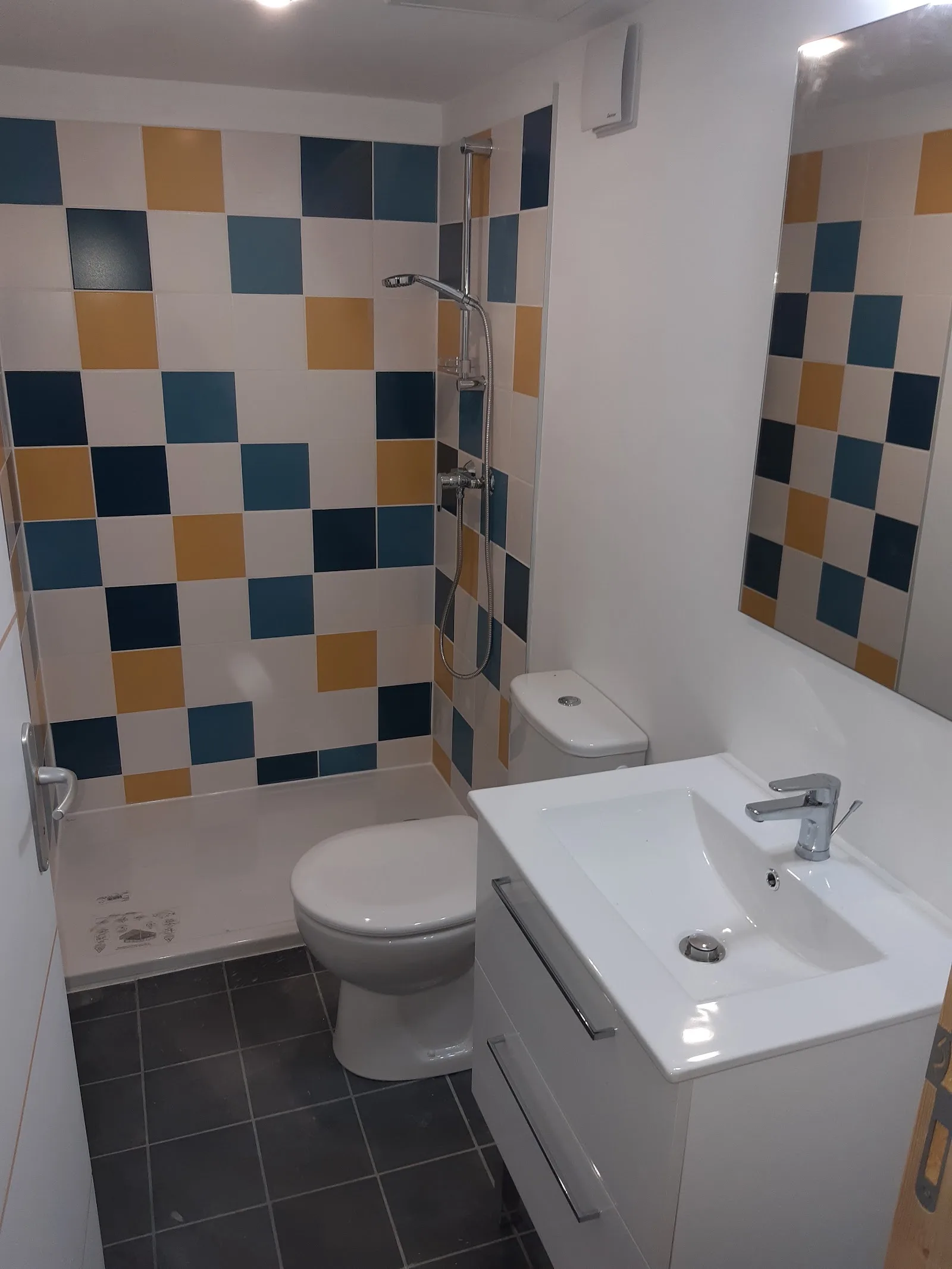 Petite salle de bain rénovée avec faïence à motif bleu et ocre