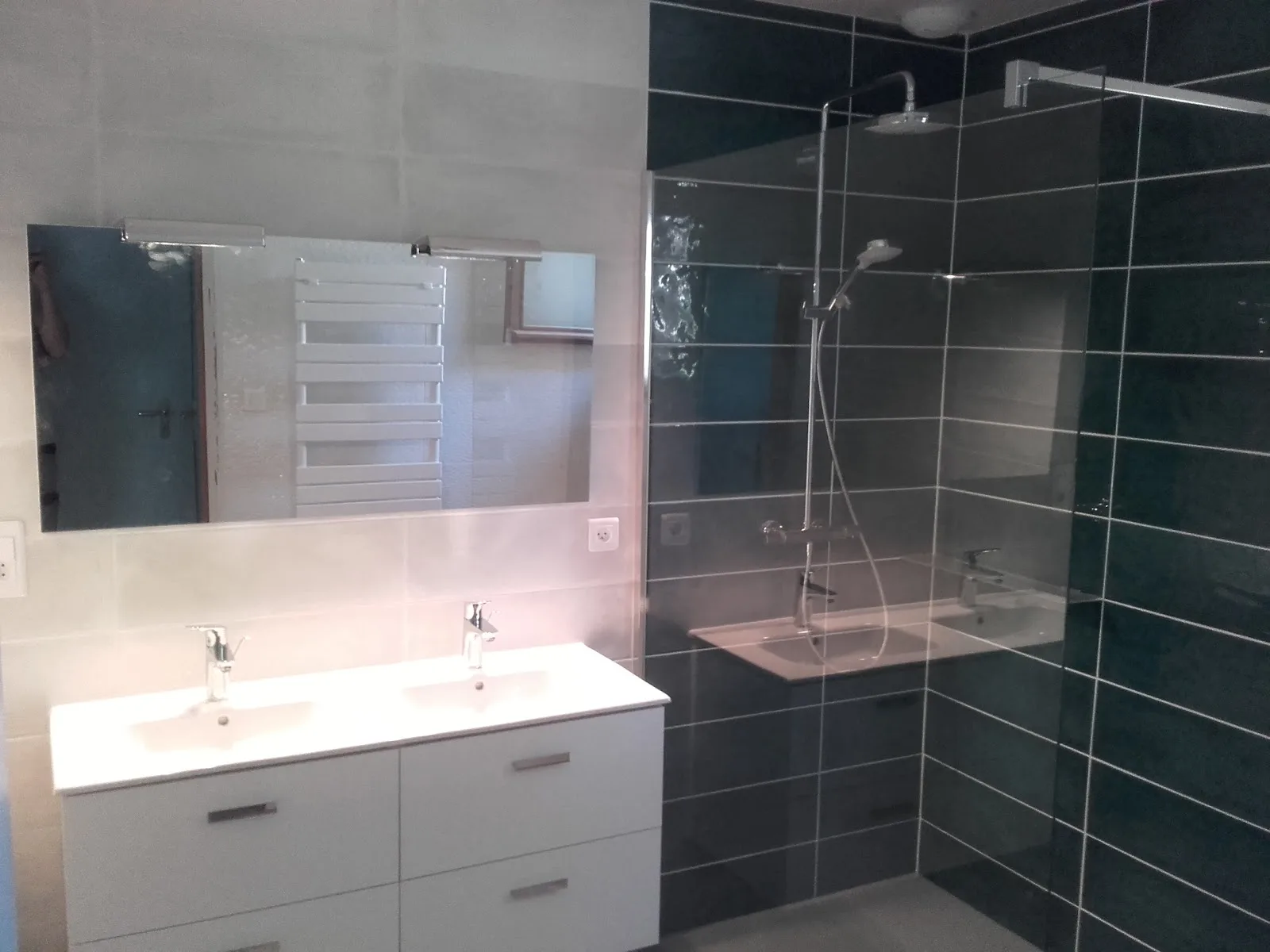 Salle de bain rénovée avec double vasque et douche à l'italienne carrelée